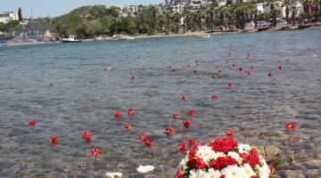 GÖÇMENLER ATALARININ ANISINA DENİZE ÇİÇEK BIRAKTI